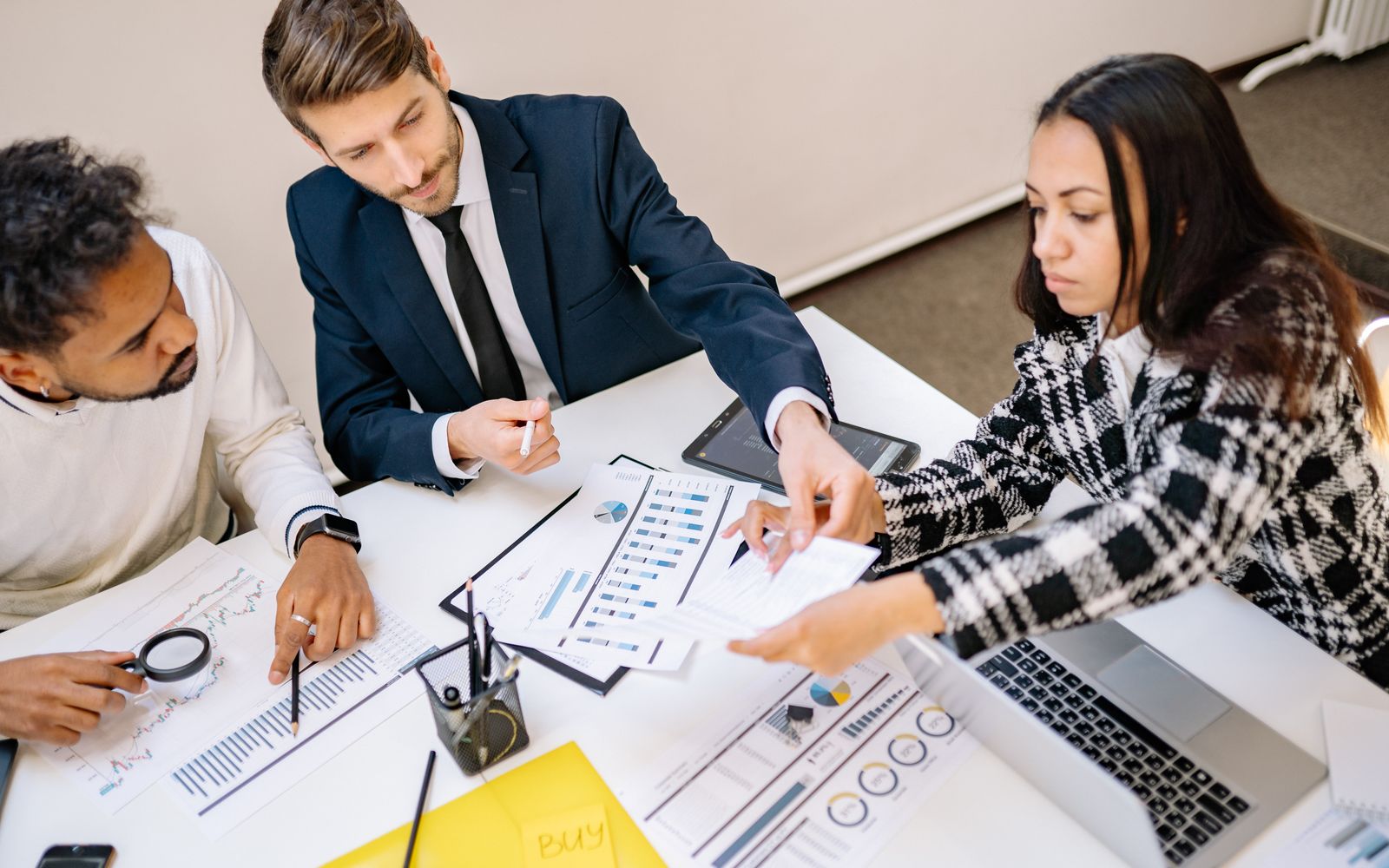 Business professionals engaging in a collaborative meeting with charts and documents.