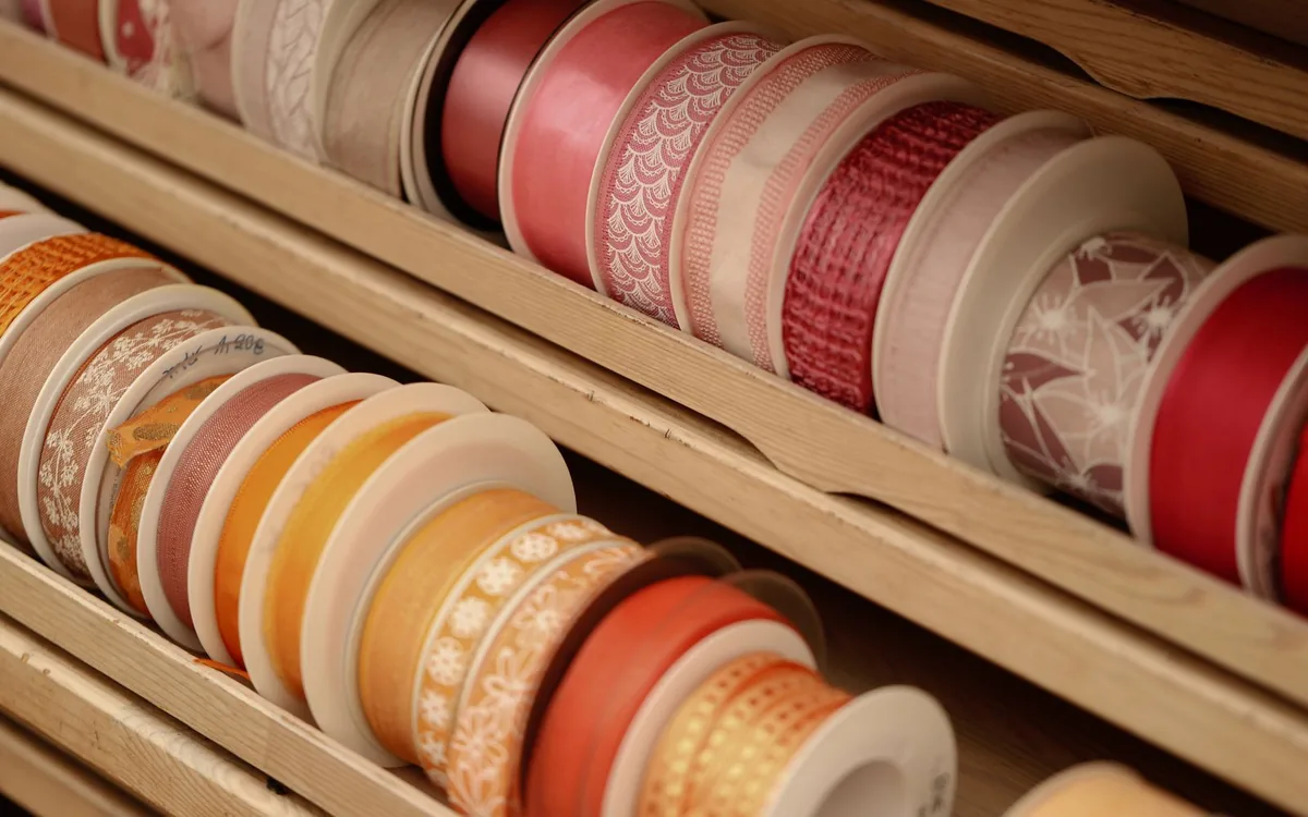 A vibrant collection of decorative ribbons neatly organized in a wooden display.