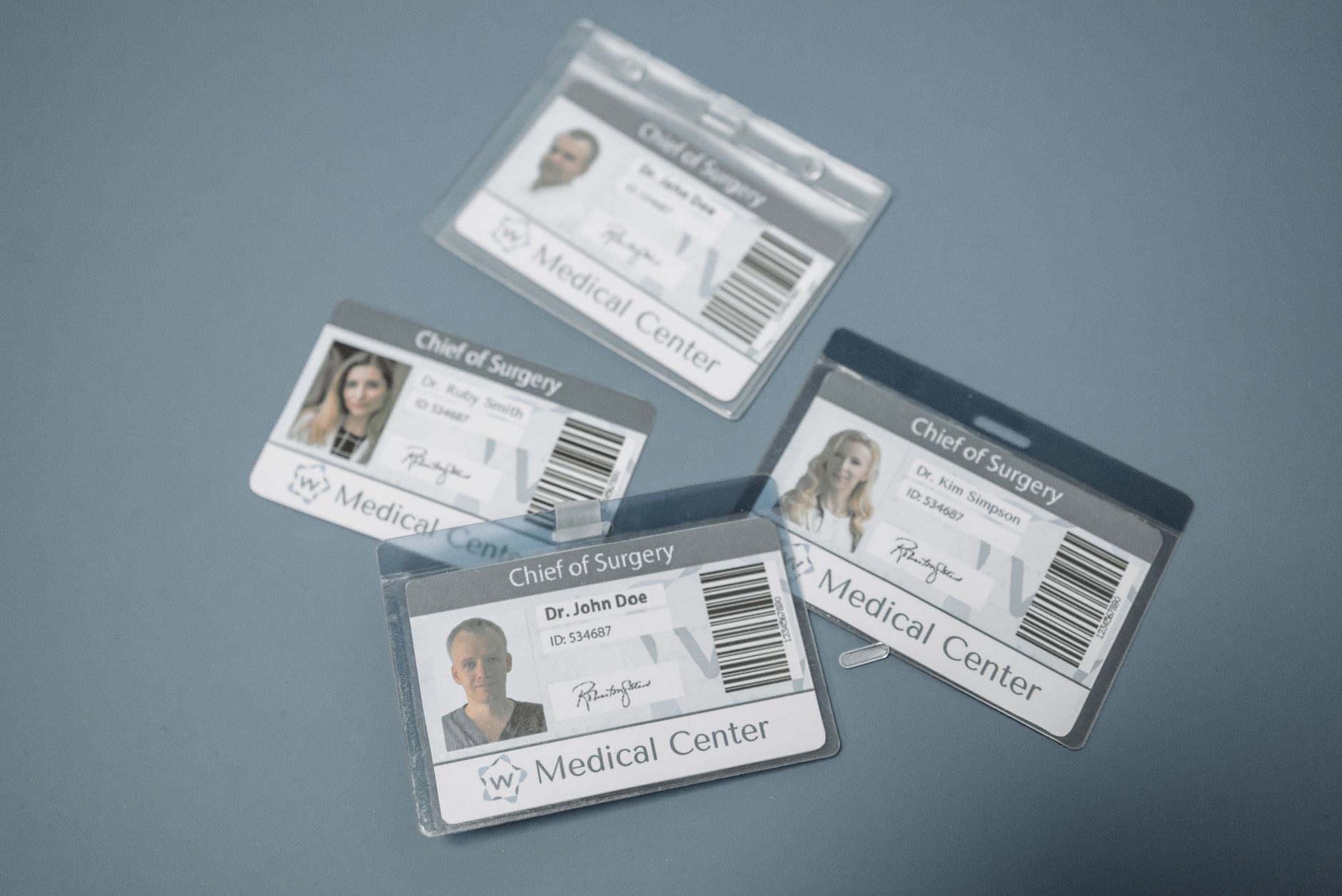 Printed photo ID badges for a medical center, showing cardholder photos, names, and barcodes.