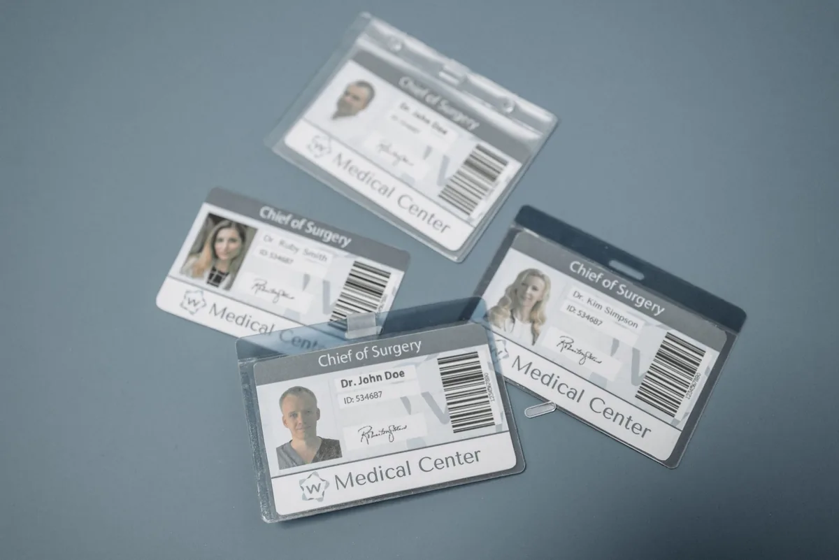 Printed photo ID badges for a medical center, showing cardholder photos, names, and barcodes.