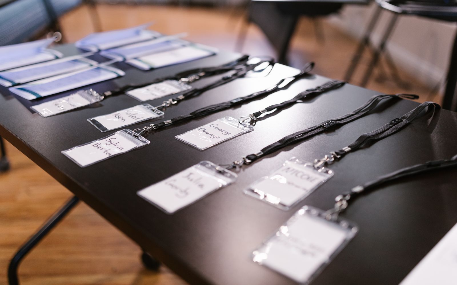 Close-up of name tags and folders laid out for a conference or meeting.