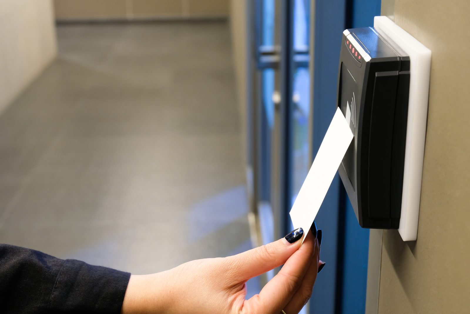 Hand using an RFID key card at an office door