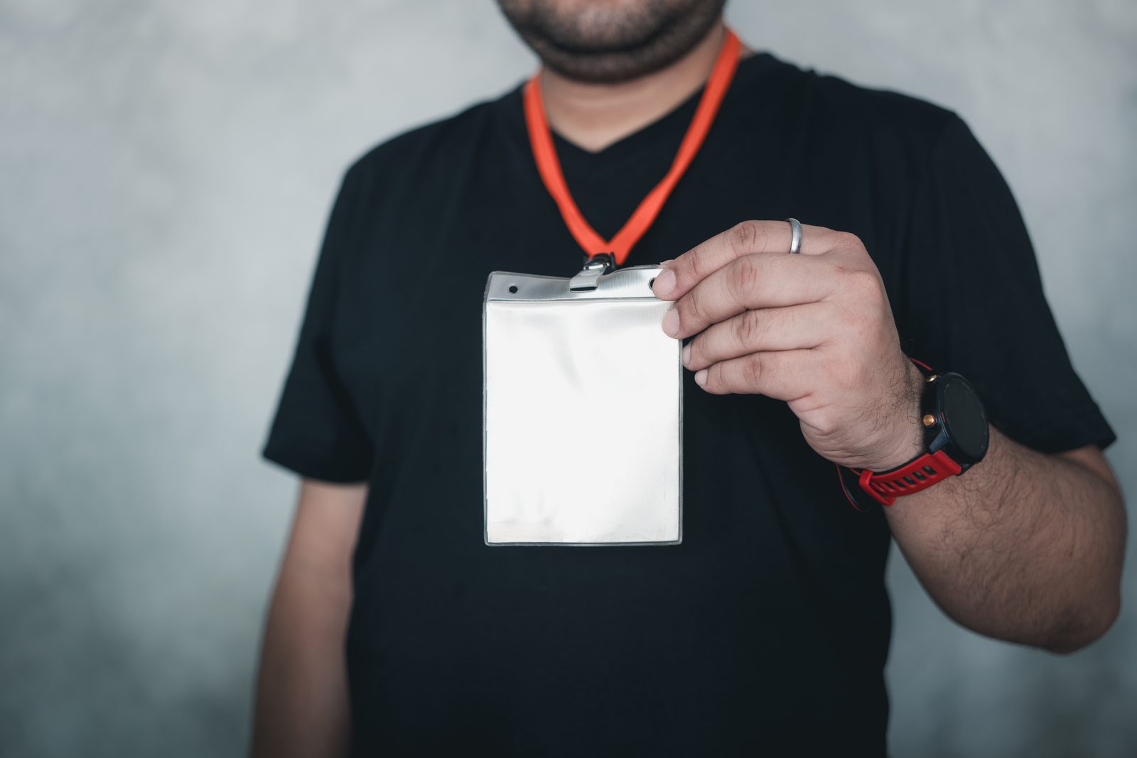 Person holding a blank event badge on a lanyard