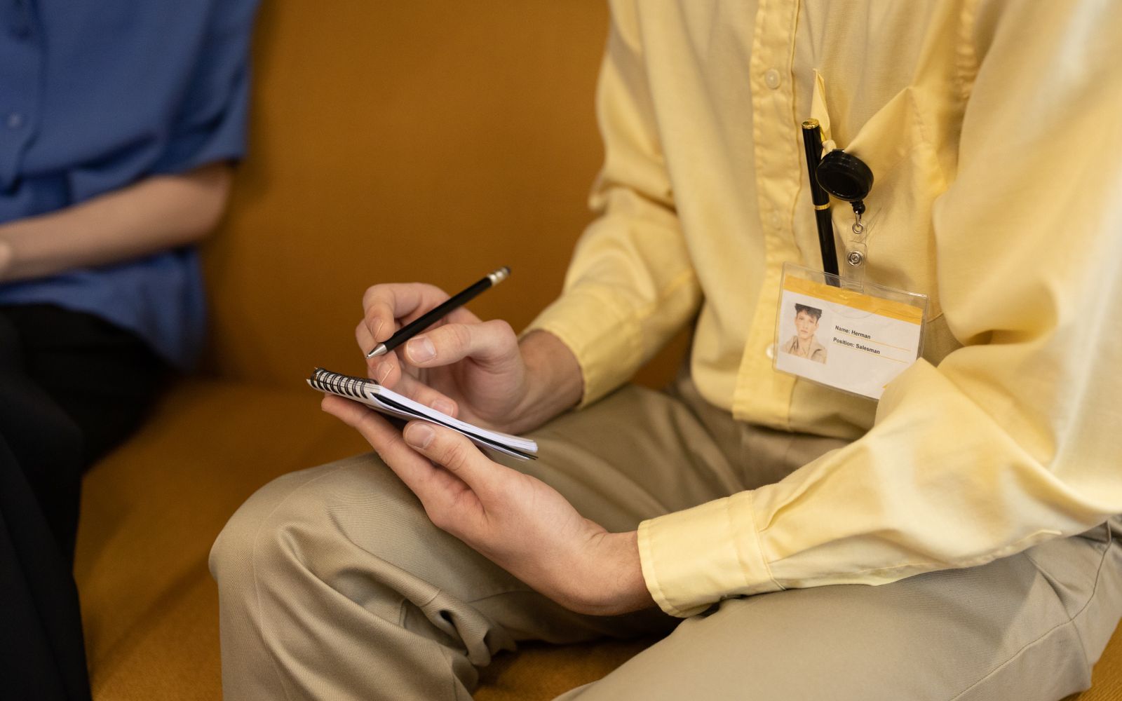 An ID badge worn on a retractable badge reel clipped to a shirt