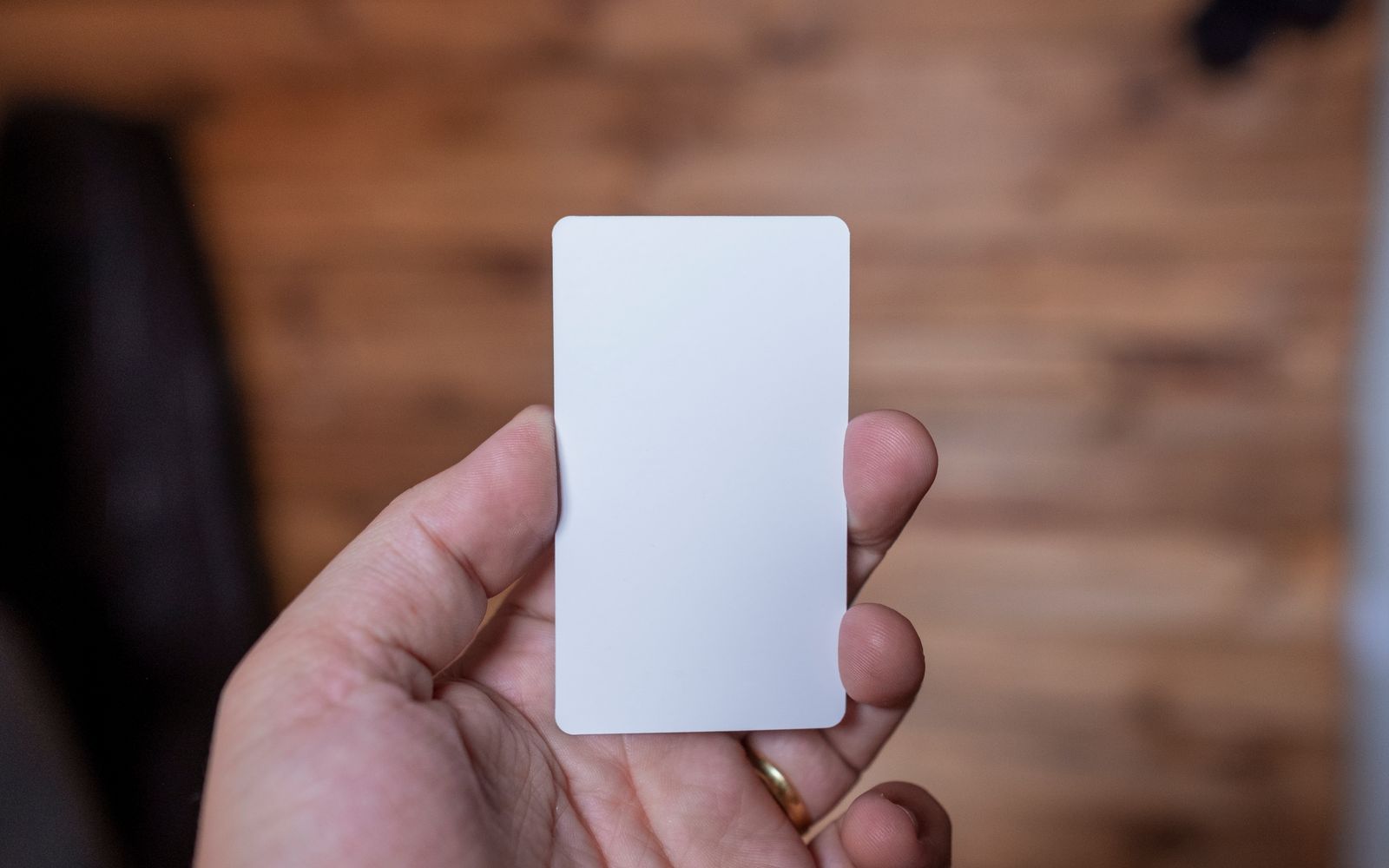 A blank CR-80 PVC card held in one hand to show its size